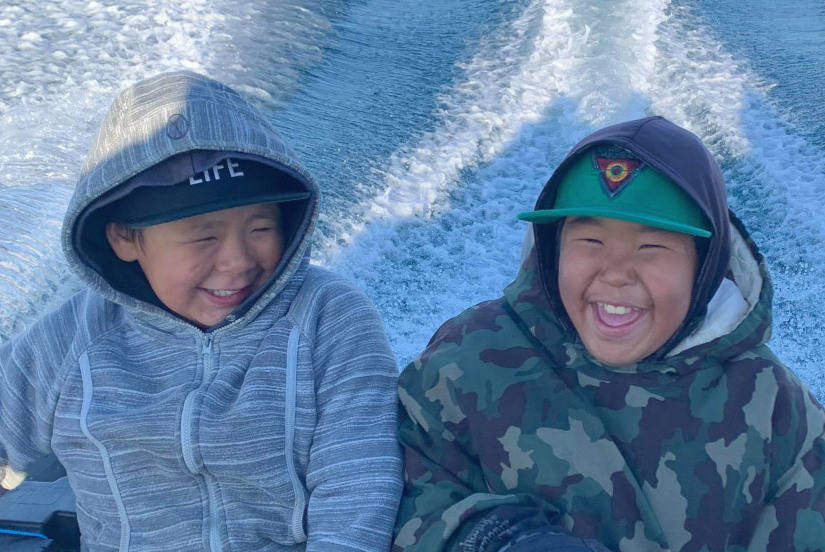 Gabriel Qimirpik, left, and Ashevak Pii are visibly elated during their late July fishing and hunting outing in Kinngait. Chris Pudlat Sr. organized a couple of trips, each involving 10 youths, to give them experience in catching char and hunting seals. Photo courtesy of Chris Pudlat Sr.