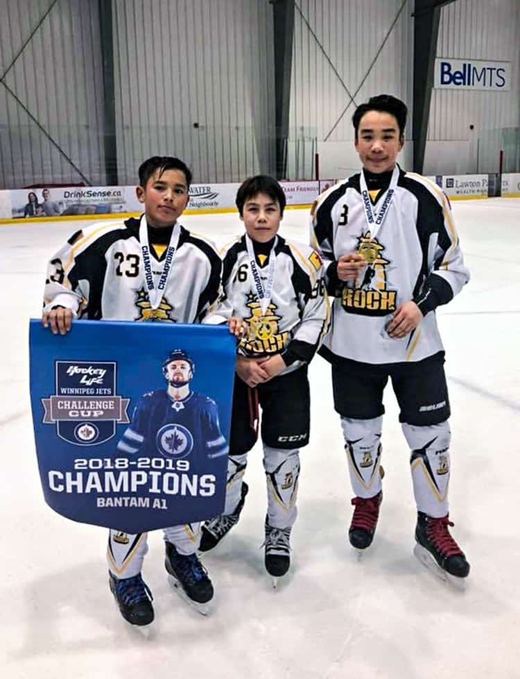 Rankin Rock bantam players, from left, Koby Connelly, Kadin Eetuk and Chase Harron celebrate with the championship banner after claiming the A1 Division at the Winnipeg Jets Challenge Cup tournament in Winnipeg, Man., on Dec. 30, 2018. Photo courtesy James Connelly