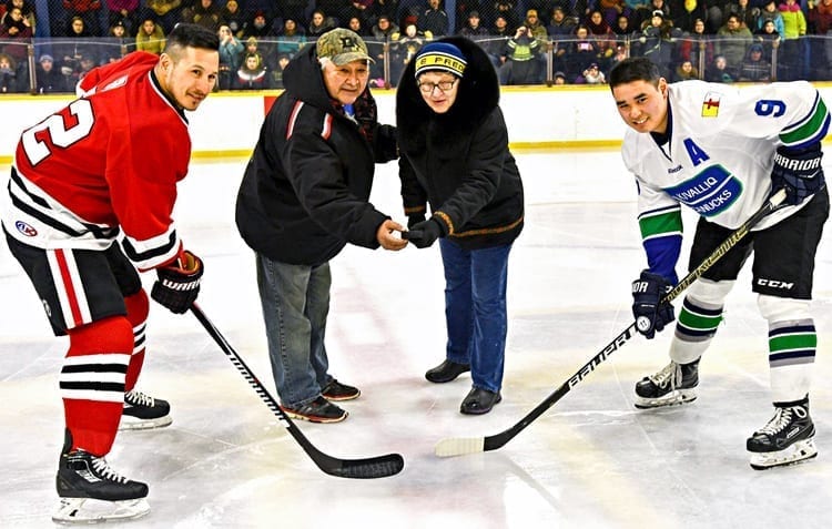 Rose and Barney Tootoo conduct the ceremonial faceoff with Jordin Tootoo, left, and Piqut Nukapiak to launch the 2019 Terence Tootoo Memorial senior men's championship in Rankin Inlet on March 8, 2019. NNSL file photo
