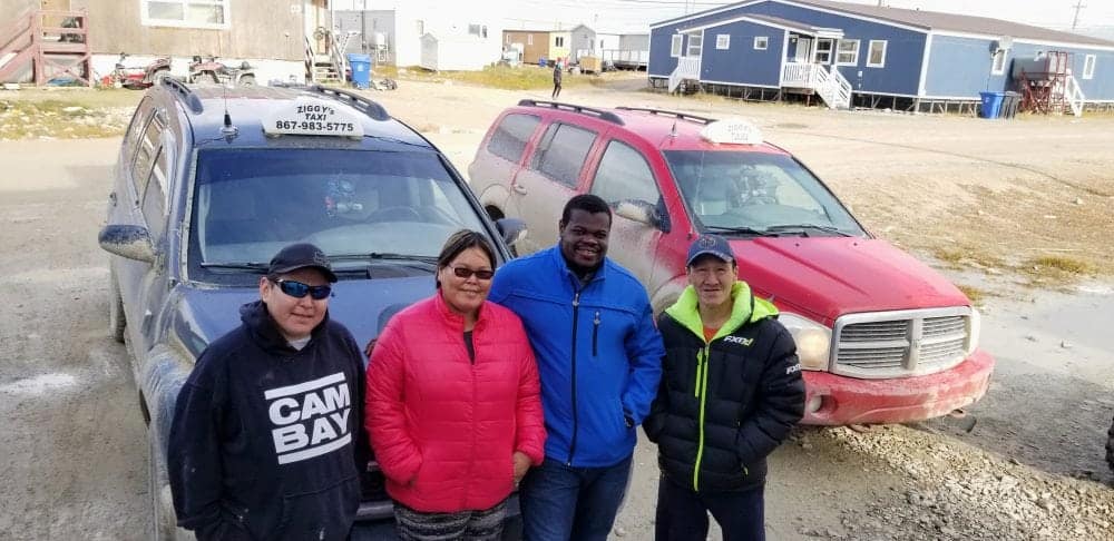 From left, Ziggy's Taxi driver Jeffrey Komak, cab company co-owners Elaine Zikalala and Charles Zikalala and driver Leonard Epilon stand with two of the company's cabs in Cambridge Bay. Zikalala is planning to offer taxi service in Kugluktuk and Rankin Inlet by October. photo courtesy of Charles Zikalala