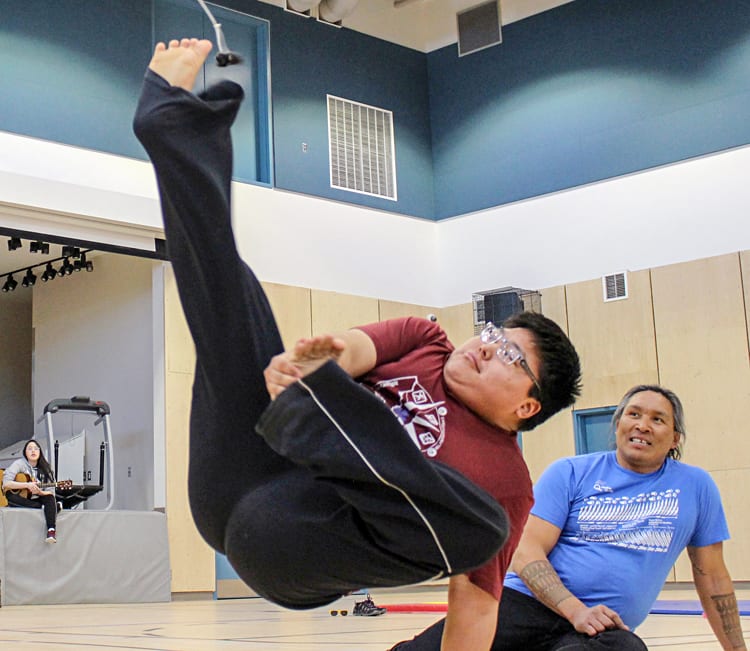 Grade 11 student Lou Kopak tries the Alaskan high kick as motivational speaker and Inuit games athlete Johnny Issaluk, right, offers words of encouragement at Tuugaalik High School in Naujaat on May 2, 2019. Photo courtesy Julia MacPherson