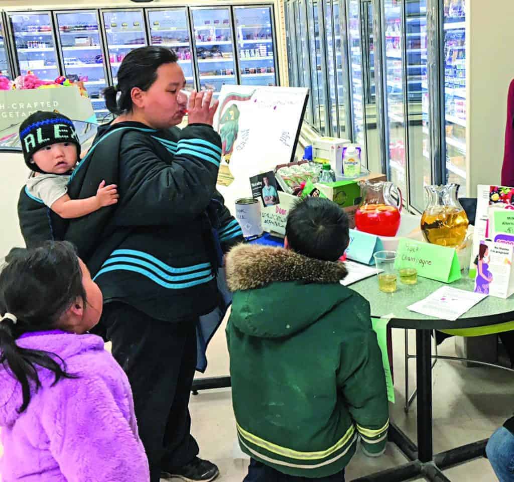 Tiriaq Aaruaq tried out a delicious Shirley Temple mocktail while children Alex, Jessie, and Isaac looked on during a Baker Lake Prenatal Nutrition Project event to celebrate International FASD day in September of 2018. photo courtesy Laurel Kreuger