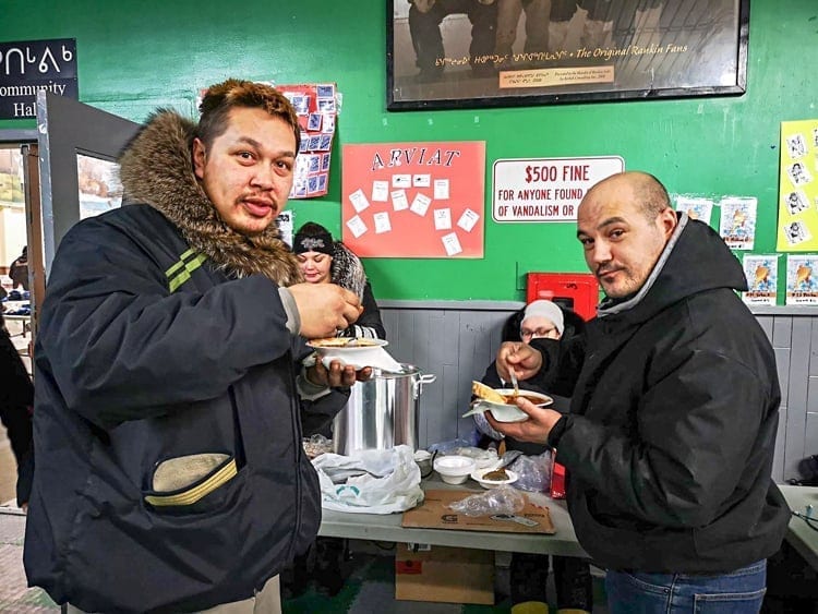Silu Autut, left, and Troy Aksalnik are half grinny and half yummy as they load-up on some delicious chile at the Rankin Inlet arena on Feb. 10, 2019. Photo courtesy Noel Kaludjak