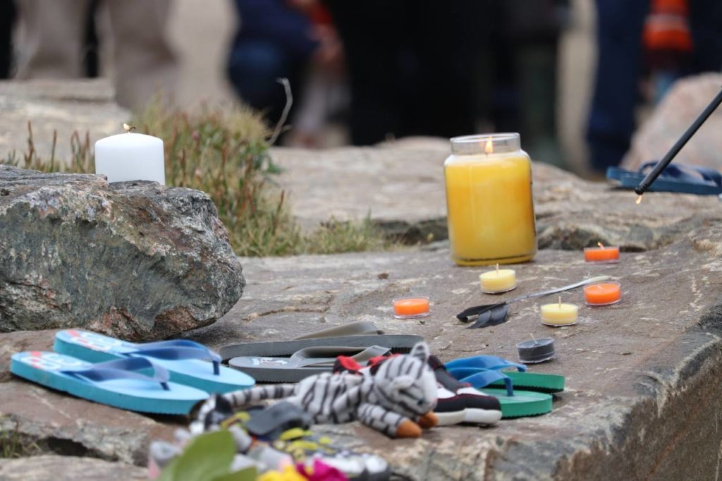                                             Shoes, flowers and candles are placed near the Legislative Assembly in Iqaluit as tokens of remembrance for victims of Canada’s residential school system. Trevor Wright/NNSL photo                            