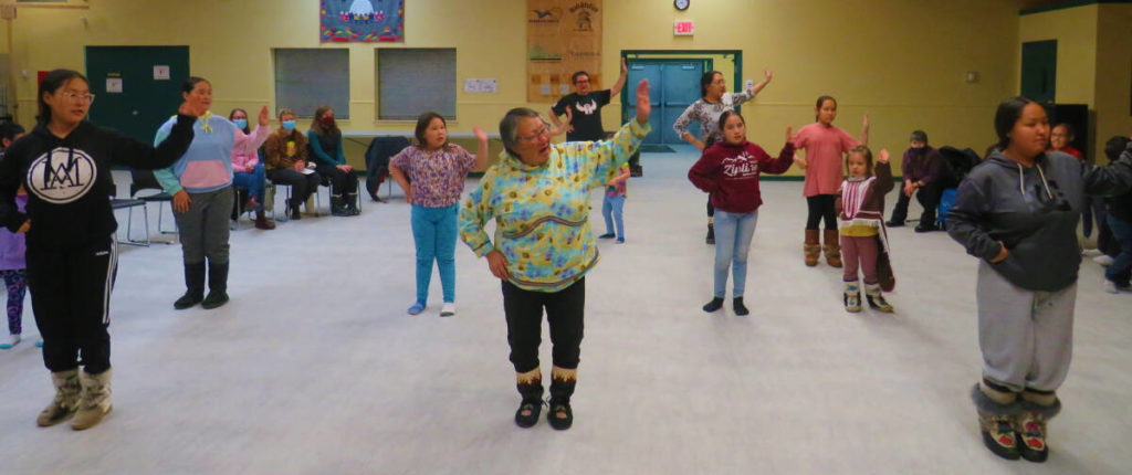 Follow the leader. Elder/organizer/teacher Julia Haogak Ogina leads the female drum dance at huqqullaaq drum dance practice in Cambridge Bay. Navalik Tologanak/NNSL photoᒪᓕᒡᓗᒍ ᓯᕗᓕᐅᖅᑎ. ᐃᓄᑐᖃᖅ / ᐋᖅᑭᒃᓱᐃᔨ / ᐃᓕᓴᐃᔨ ᔪᓕᐊ ᕼᐊᐅᒐᒃ ᐅᔩᓇ ᑐᕌᖅᑎᑦᑎᕗᖅ ᐊᕐᓇᓄᑦ ᒧᒥᕐᓂᕐᒥ ᕼᐅᖅᑯᓪᓛᖅ ᕿᓚᐅᔾᔭᕐᓂᕐᒧᑦ ᐱᔭᕆᐅᖅᓴᓂᕐᒥ ᐃᖃᓗᒃᑑᑦᑎᐊᕐᒥ .