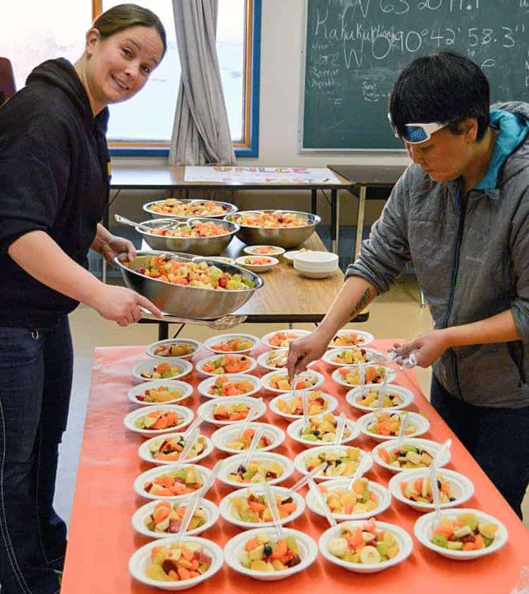 Vice-principal Ana Leishman, left, and student support assistant Jolene Ippiak prepare delicious fruit salad for Uncle Bob's (Carveth) Breakfast at Victor Sammurtok School in Chesterfield Inlet on Nov. 19, 2018. Photo courtesy Glen Brocklebank