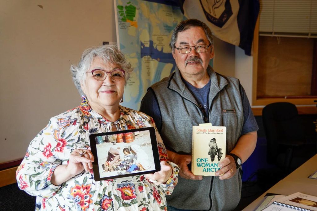                                             The documentary’s Inuk guide Navalik Tologanak, left holds a tablet playing footage taken by Shelia Burnford and Pond Inlet mayor Joshua Arreak holds a copy of One Woman’s Arctic, which Burnford also penned. Photo courtesy of ShebaFilms                            