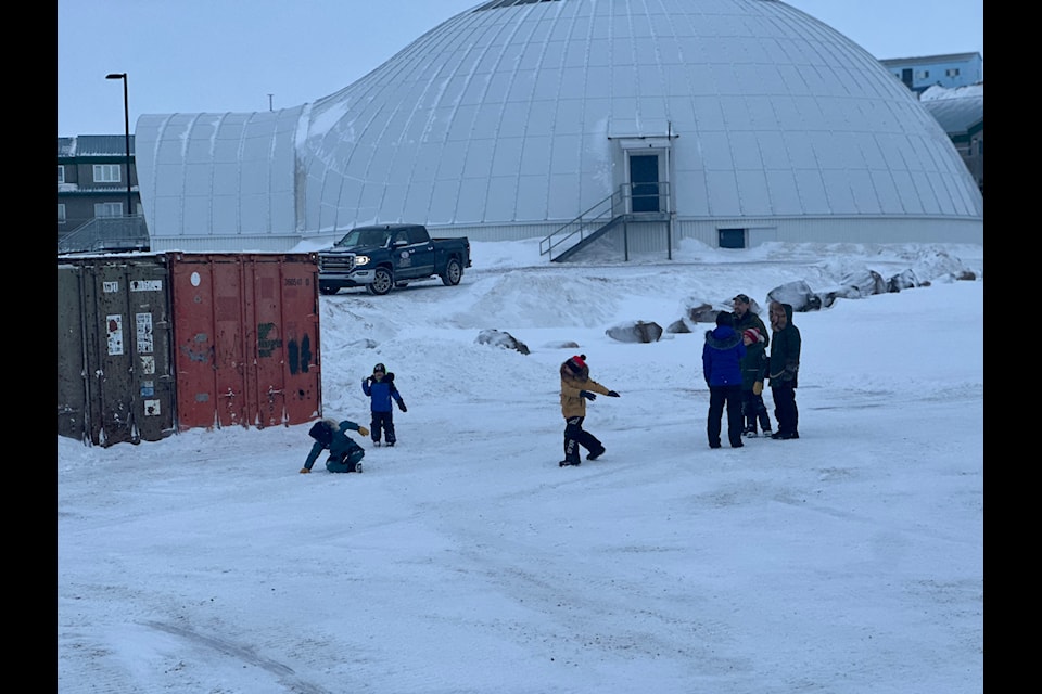 Children have a snow fight while waiting for the event to begin.
