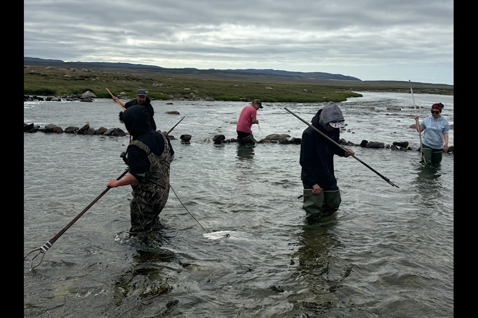 Workshop participants use their newly-made kakivak at Kugaaruk River. 