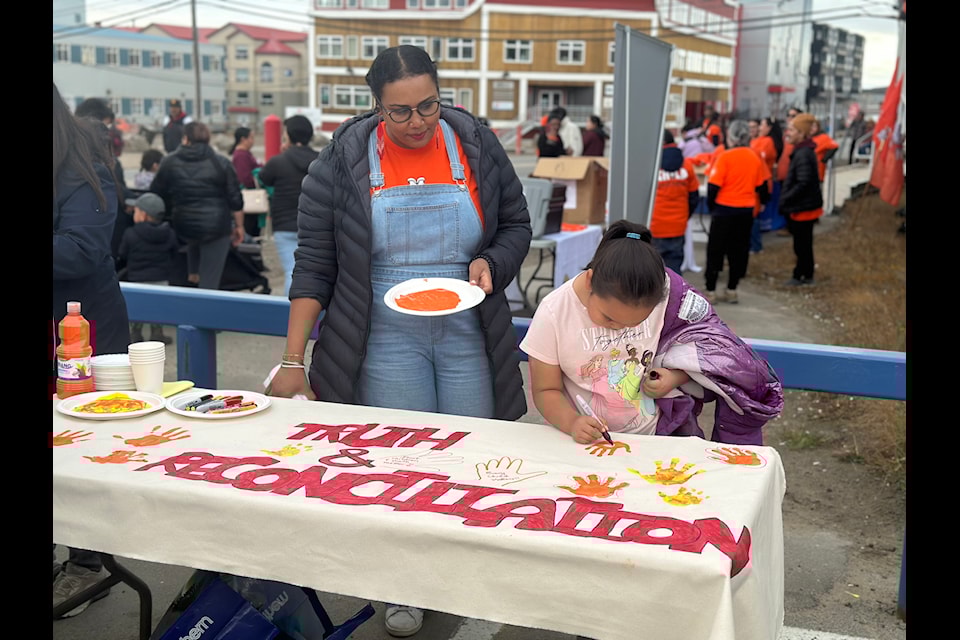 Kamala Ramadan, manager of Iqaluit Mental Health, staffs the table for children's hand prints as well as promoting the city's mental health services.