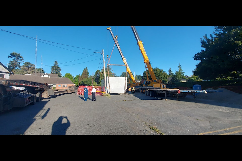 A temporary fire hall structure, on a trailer measuring 46 by 5.22 metres with a total weight just under 100 tons, lands in Oak Bay on July 16. 