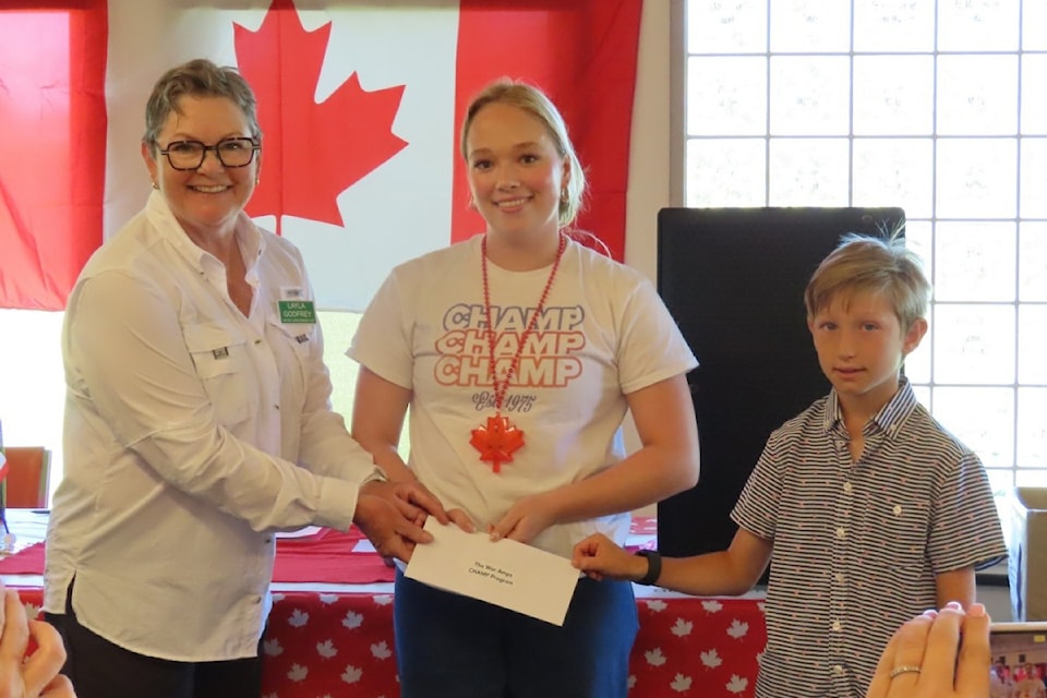 Tournament organizer Layla Godfrey hands off $7,000 raised in Oak Bay for the War Amps CHAMPS program.