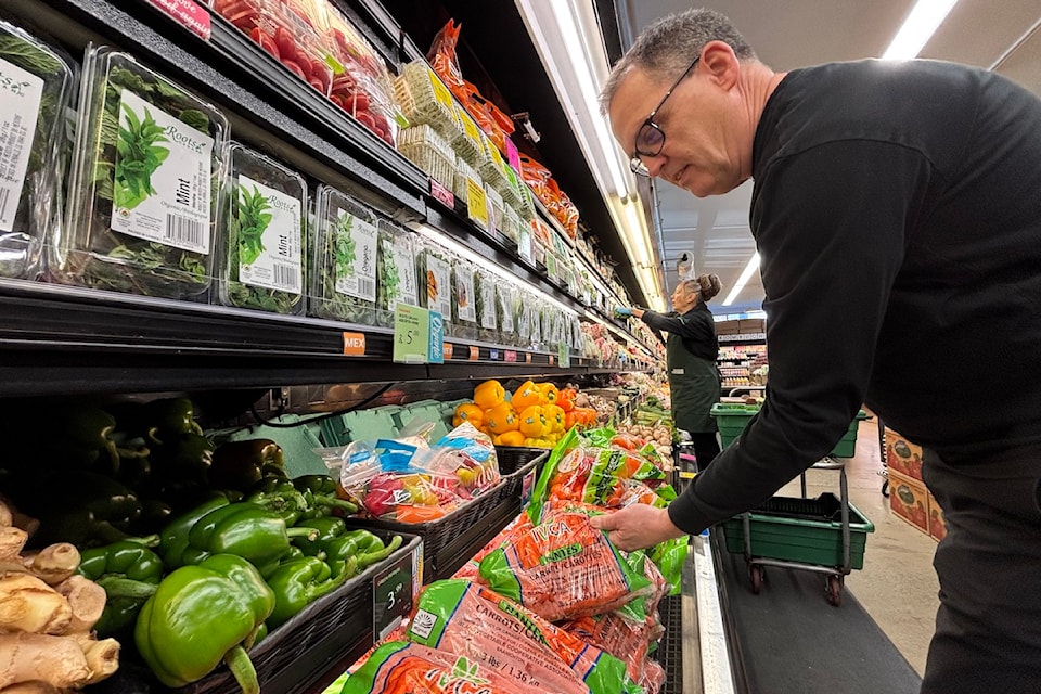 Urban Grocer's general manager Gary Innis holds a local alternative to U.S. carrots.