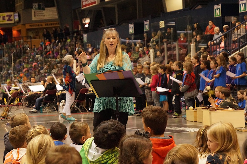 Maureen Lauren, principal and music teacher at Sangster Elementary, leads about 2,000 elementary grade students in a medley of songs. Rick Stiebel/News Gazette staff