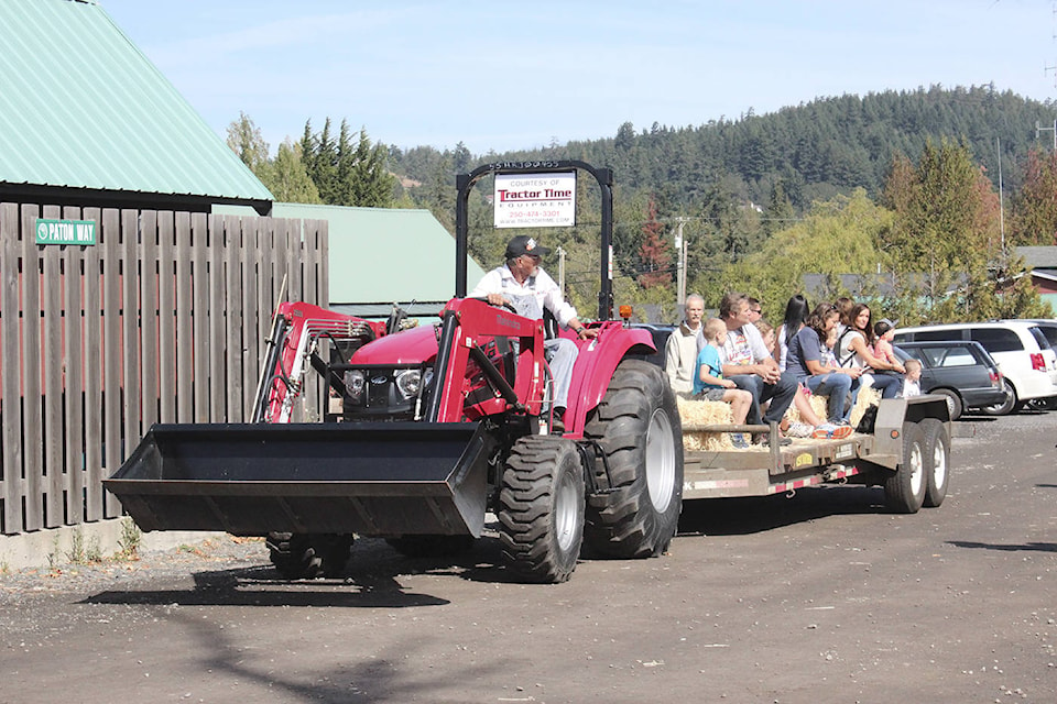 Residents take a tractor ride during the 50th annual Metchosin Day at the municipal grounds on Sunday (Kendra Wong/News Gazette staff).