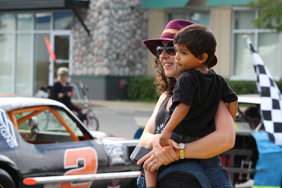 Shelley Ruggles and her two-year-old son, Isaak De Quadros, watch race cars drive by at City Centre Park. Race cars cruised through the streets of Langford Saturday morning from the Western Speedway to City Centre Park to celebrate the drivers and Canada 200 weekend. (Shalu Mehta/News Staff)