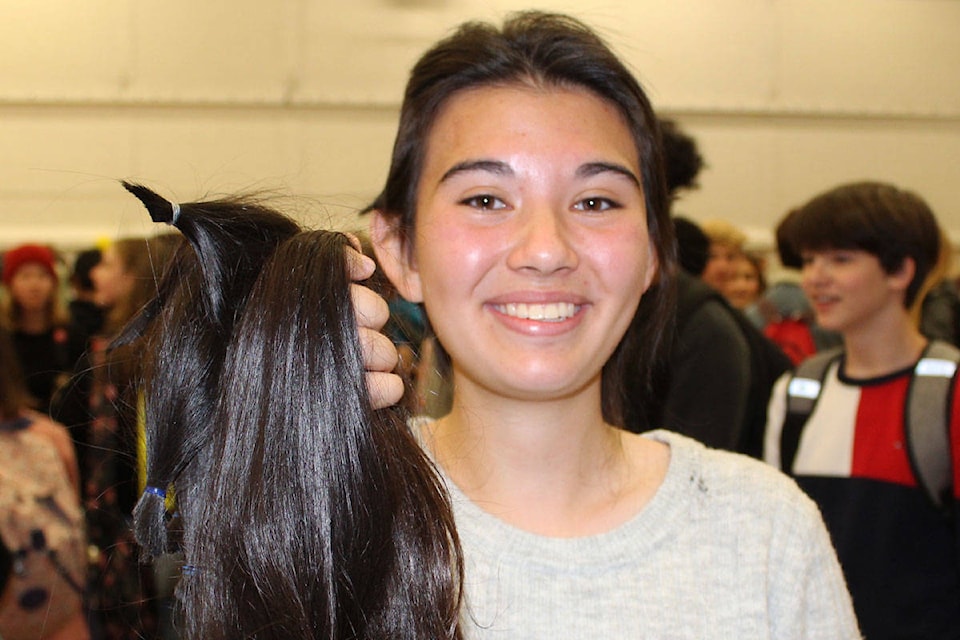 Grade nine student Erika Boutilier was handed a pile of her recently chopped ponytails before being ushered over to have the rest of her hair shaved off. (Devon Bidal/News Staff)