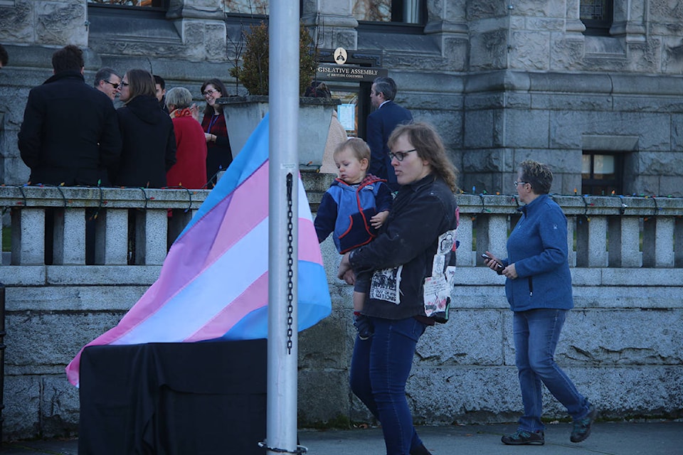Supporters of Transgender Day of Remembrance check out the flag before it’s raised outside the B.C. Legislature. (Kendra Crighton/News Staff)