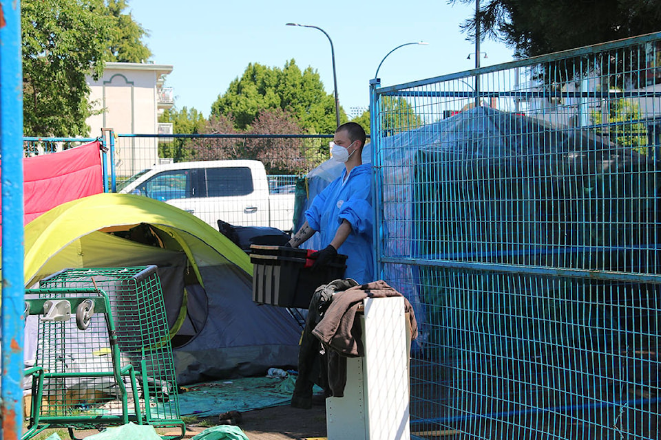 Bylaw officers stand ready to pack up people’s tents as they move into hotels. (Kendra Crighton/News Staff)