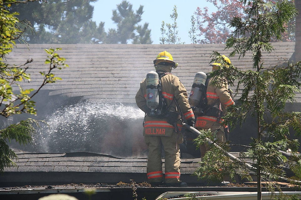 Firefighters douse hotspots inside a home that went up in flames on Thursday. (Kendra Crighton/News Staff)