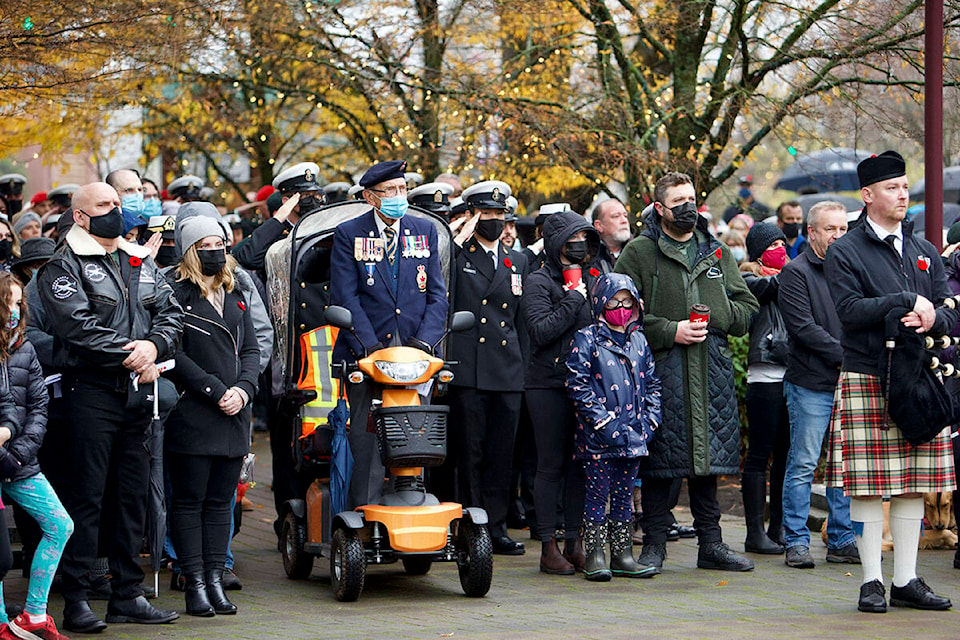 Veterans, Canadian Armed Forces members and the general public stand for O Canada during the 2021 Remembrance Day ceremony in Langford Thursday. (Justin Samanski-Langille/News Staff)