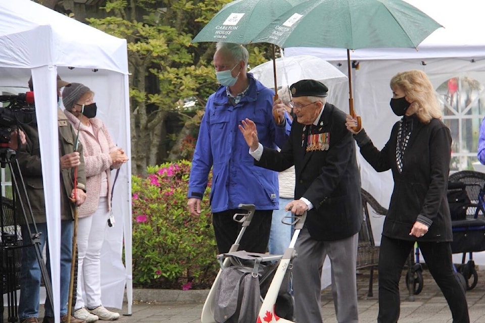 David Black owner of Black Press Media (left) and Judi Prewett, president of Carlton House, flank veteran John Hillman, 103, as he laps the Oak Bay courtyard to raise funds for Save the Children. (Christine van Reeuwyk/News Staff)