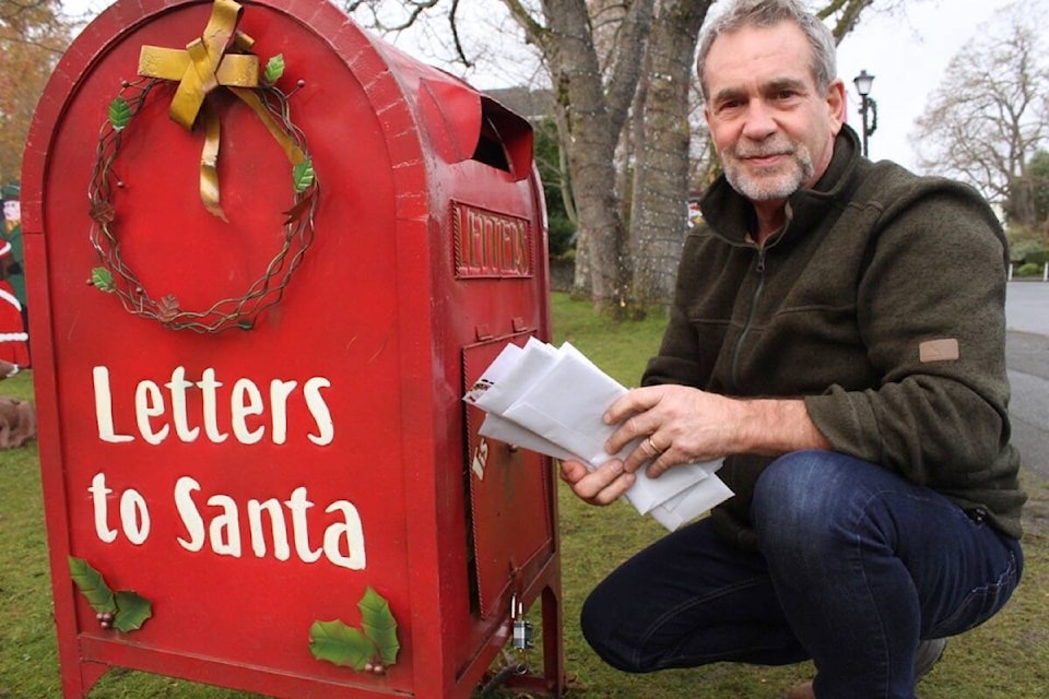 Chris Hyde-Lay, manager of the parks department for Oak Bay, empties the mailbox at municipal hall to get them on their way to St. Nick himself. (Christine van Reeuwyk/News Staff)
