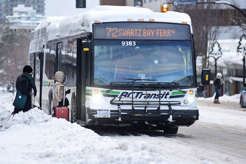 A #72 transit bus headed for the Swartz Bay ferry terminal stops to pick up passengers on a snowy Douglas Street at Fort Street. BC Transit buses are back on the Victoria streets Wednesday (Dec. 21) after the previous day’s snowstorm that halted all transit service. (Don Denton/Black Press Media)