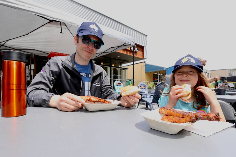 Richard and Emma Stern, 6, dig into their meals Saturday, June 17, during the Oak Bay Spring Nosh. (Justin Samanski-Langille/News Staff)