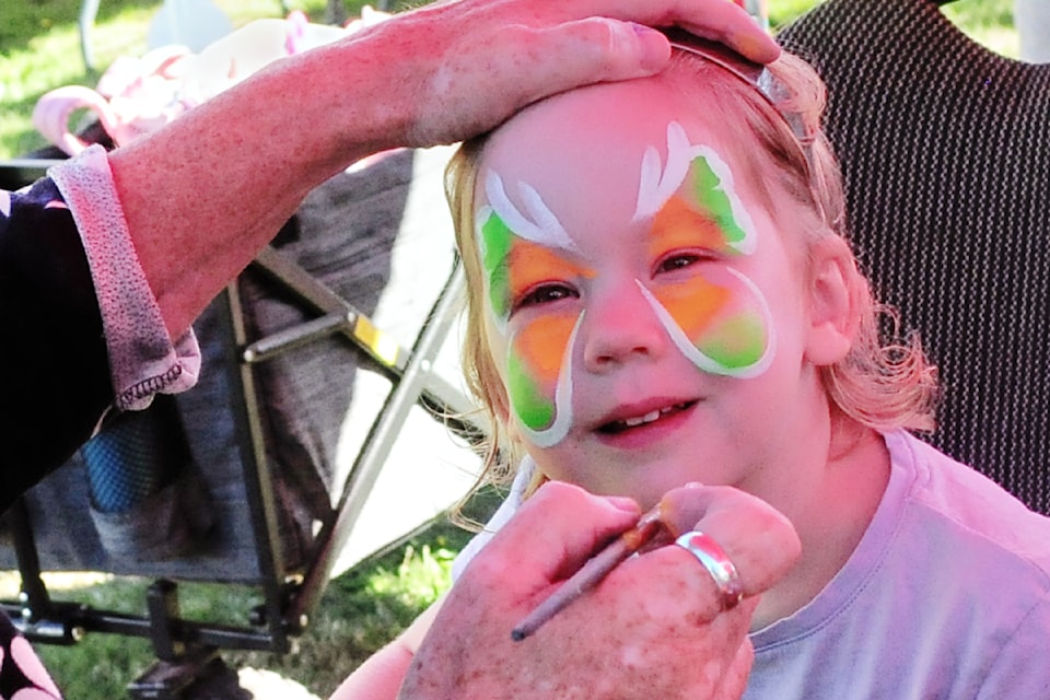 FACE PAINTING: Reya Drake, 2, smiles as she gets her face painted with colourful designs. (Michael Briones photo)