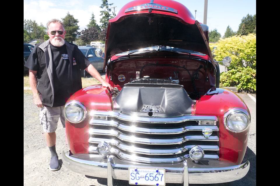 Chris Haugh stands with his 1953 Chevy Deluxe Cab truck.