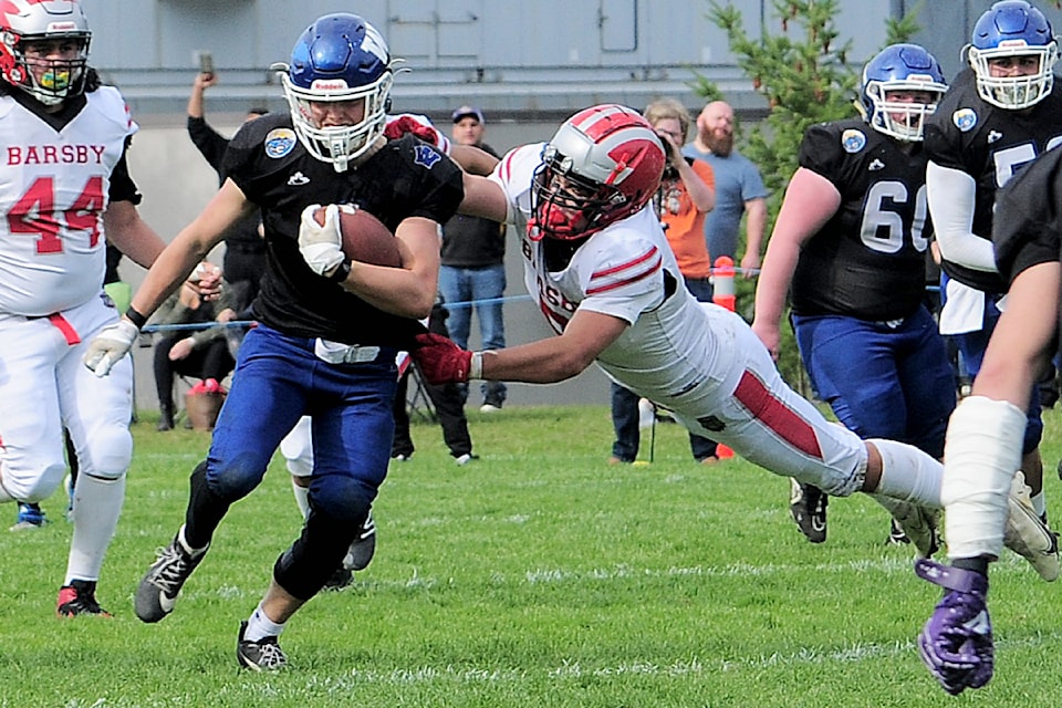 Ballenas Whalers running back Jordan Spencer gets caught by a John Barsby Bulldogs player who dove to get hold of him. (Michael Briones photo)