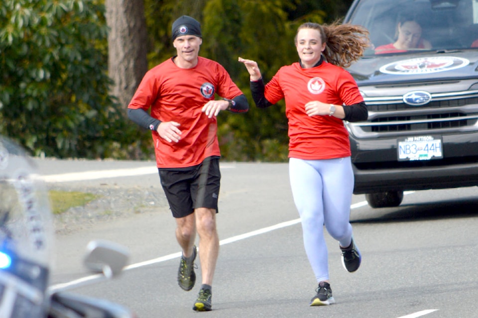 Victoria Police deputy chief Jason Laidman is surprised by daughter Emily who ran five kilometres to their next destination, the Qualicum Beach Royal Canadian Legion Branch 76.