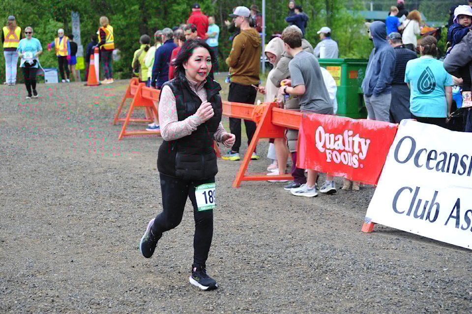 PQB News staff member Cheryl Lee is all smiles as she runs to the finish line at the Oceanside Mother's Day 5K Race. 