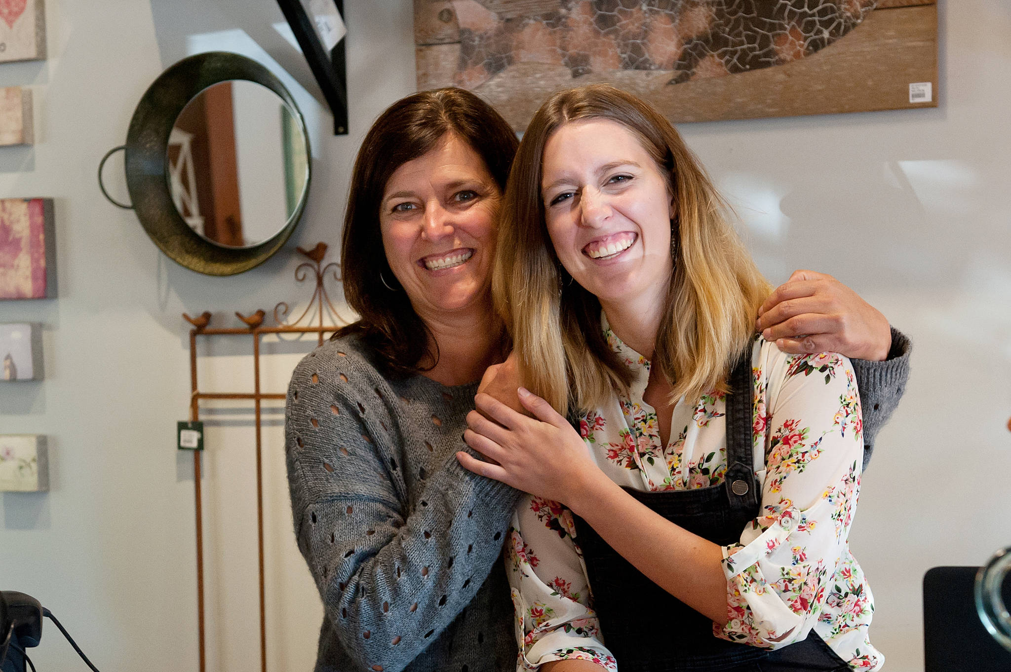 J.R. Rardon photo Susan Stark, left, hugs daughter Grace behind the counter of Captivating Details in downtown Qualicum Beach. The co-owners will open Oct. 1 in a newly renovated building they purchased just up the street from their current location.
