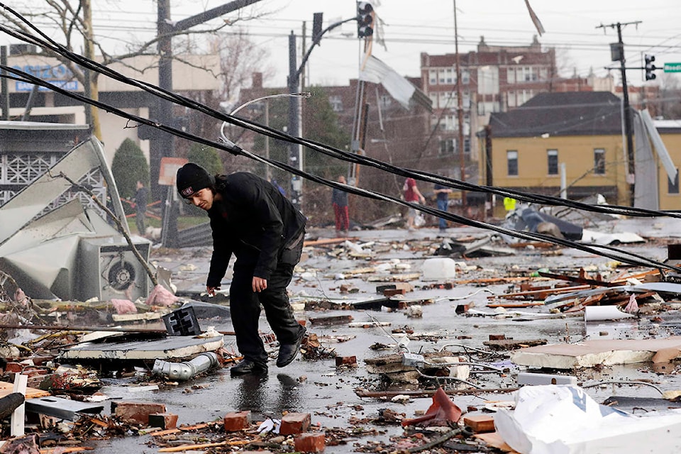 A man walks through storm debris following a deadly tornado Tuesday, March 3, 2020, in Nashville, Tenn. Tornadoes ripped across Tennessee early Tuesday, shredding buildings and killing multiple people. (AP Photo/Mark Humphrey)