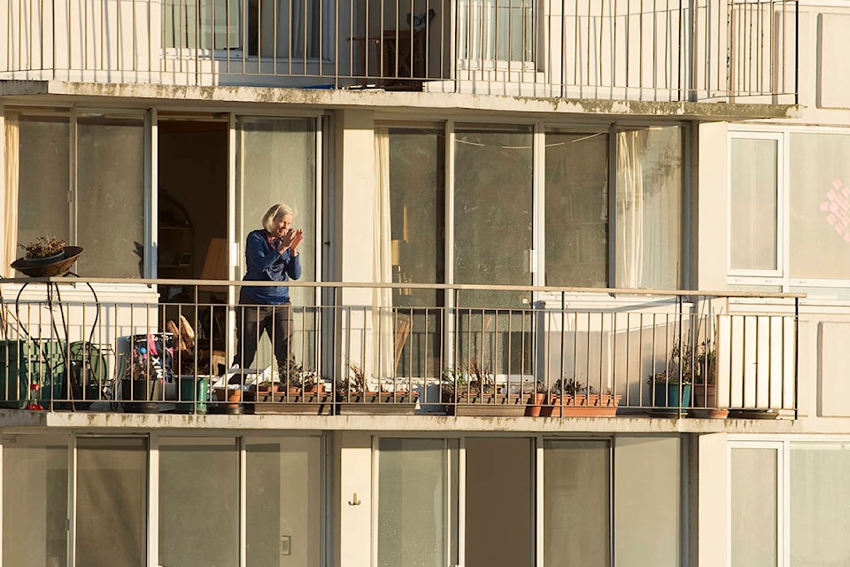 People are seen clapping on their balconies in Vancouver, B.C. Tuesday, March 24, 2020. Thousands of people in Vancouver’s west end have been going out on their balconies to applaud the front line heath care workers each night at 7pm. THE CANADIAN PRESS/Jonathan Hayward