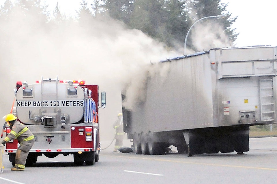 Nanoose Volunteer Fire Department firefighters hosed down a pile of garbage that was hauled out from a semi-trailer that caught fire at the Parksville weigh station on Tuesday, April 28. (Michael Briones photo)
