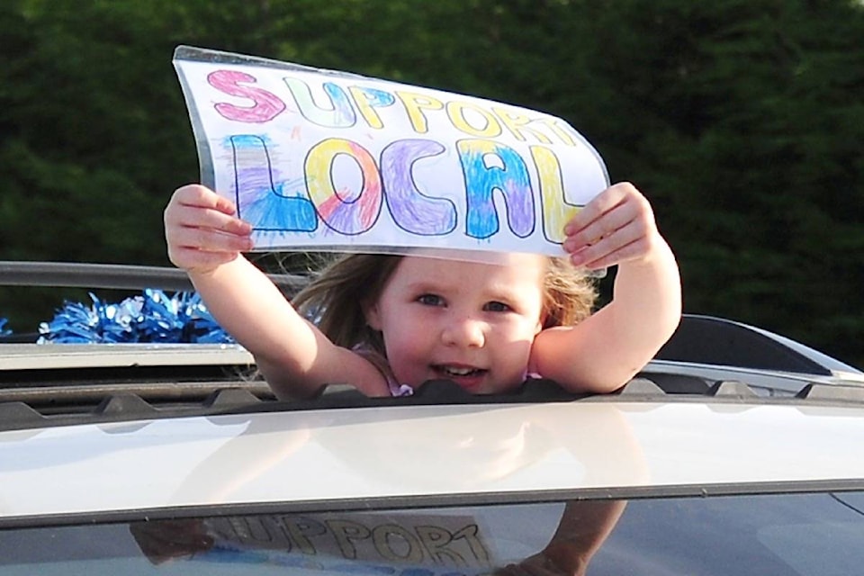 Gemma Wiebe shows her sign during the Support Local parade in Parksville. (Michael Briones photo)
