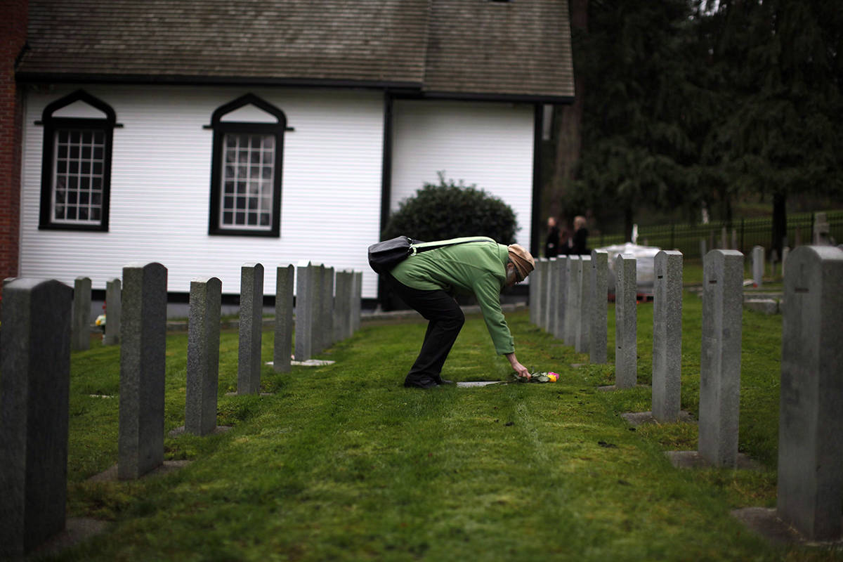 A woman lays flowers following Remembrance Day ceremonies at Gods Acre Veterans Cemetery in Victoria, B.C., on Sunday, November 11, 2018. THE CANADIAN PRESS/Chad Hipolito