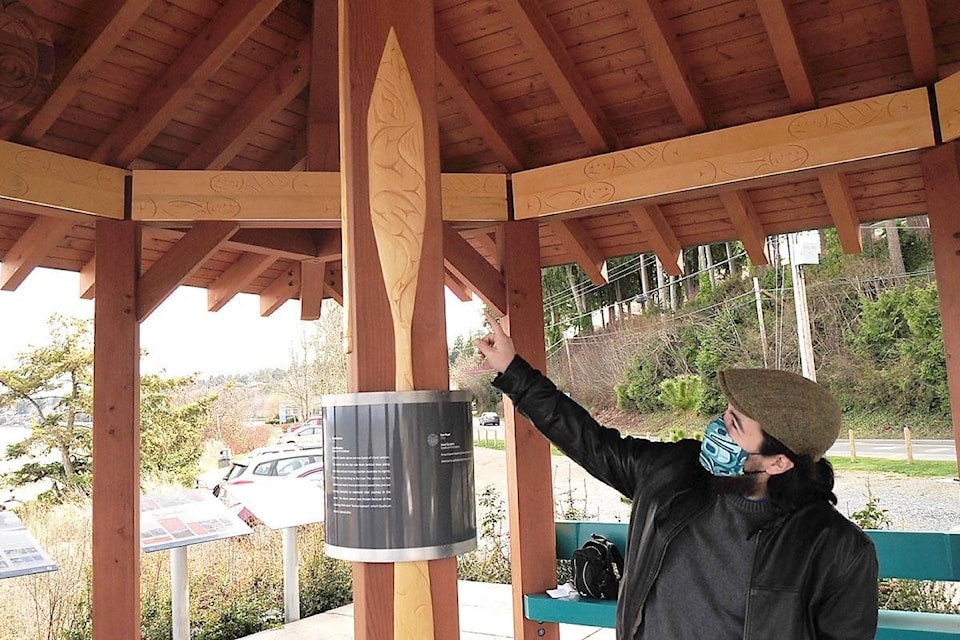 Qualicum First Nation carver Jesse Recalma shows one of the paddles featuring a sea serpent, on display at the Seaside Park Faye Smith Rosenblatt Memorial Pavilion in Qualicum Beach. (Michael Briones photo)