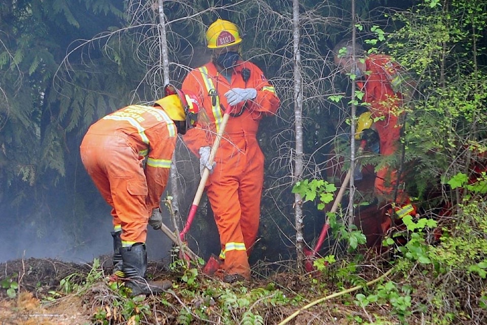 Coombs Hilliers Volunteer Fire Department crews dig through the ground in search of hot spots as they took out a fire on Redman Road (May 8). (Michael Briones photo)