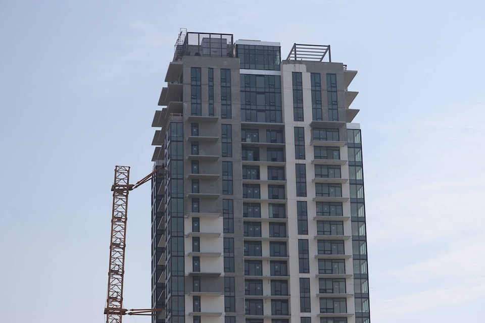 The collapsed crane at a downtown Kelowna construction site is slightly shorter on Wednesday, July 14, after crews completed the first stage of its disassembly. (Aaron Hemens/Capital News)