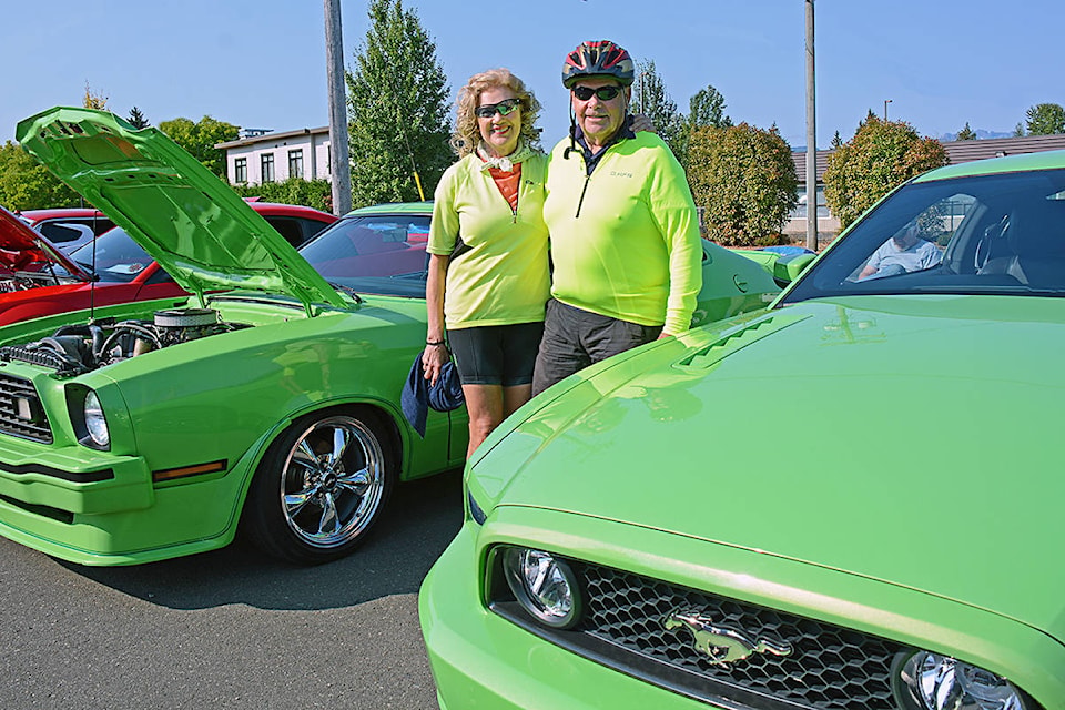 DOUBLE CHINNS: Allison and Wally Chinn of Parksville blend right in between a 1978 King Cobra a 2014 Mustang GT during a special Mustang show Saturday, Aug. 21 at Family Ford in Parksville. Allison is the owner of five Mustangs to date and her current licence plate reads ‘Mustang Ally’.