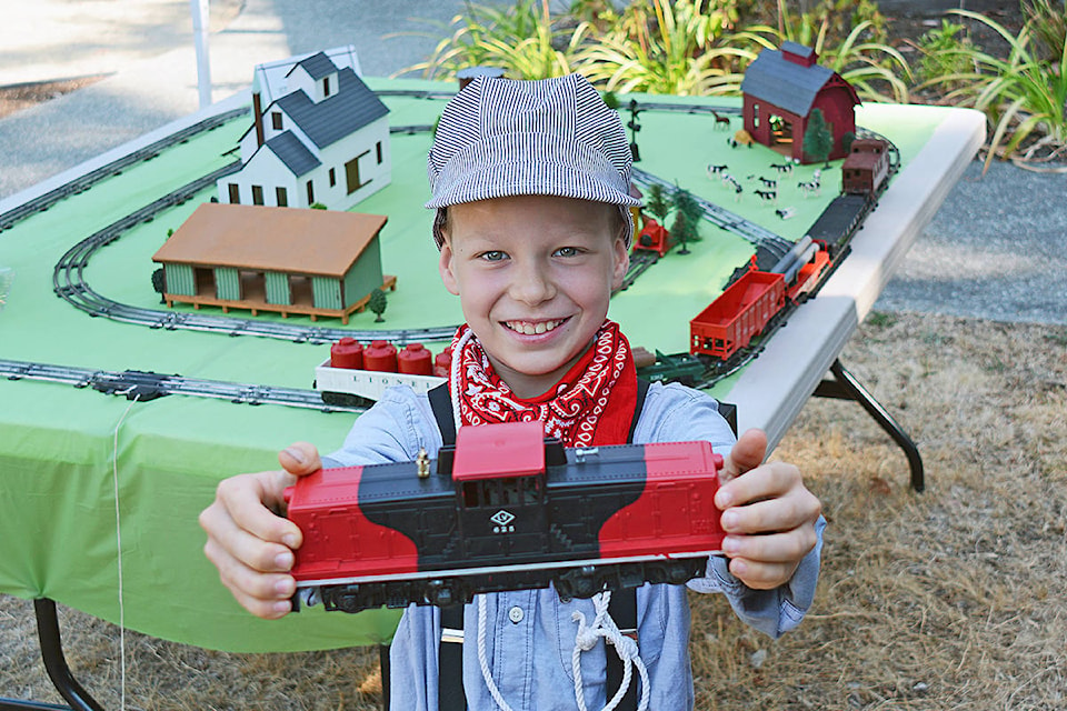 The Parksville Museum and the Oceanside Model Railroaders celebrated Railway Day at the museum, located at 1245 Island Highway, on Aug. 21. Pictured, Troy Springford shows off a car from the 1957 Lionel O-Scale Model Train set that he was given by his late grandfather Colin Springford. Troy received the train set on his eighth birthday, his grandfather had received it on his 12th birthday. He and his father have added the buildings, the scenery and the log car. (Peter McCully photo)