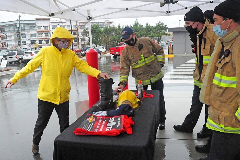 Despite the rain, residents take the time to donate to the annual ‘Fill the Boots for Food Drive’ fundraiser for that was set up the Parksville Fire Department volunteers at Quality Foods in Parksville. (Michael Briones photo)