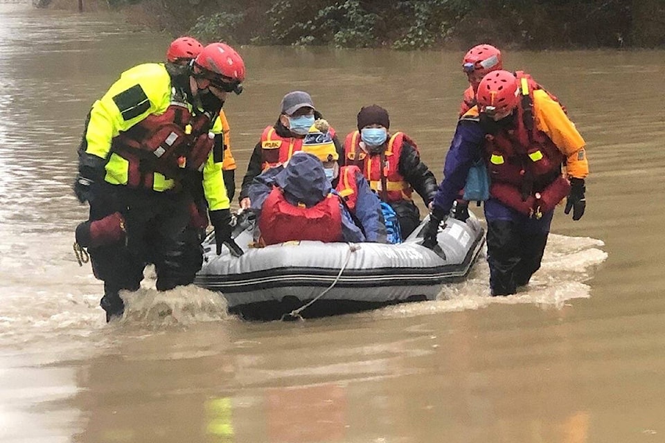 Members of the Arrowsmith Search and Rescue help residents evacuate from their homes along Martindale Road in Parksville due to flooding on Jan. 2, 2021. (Michael Briones photo)