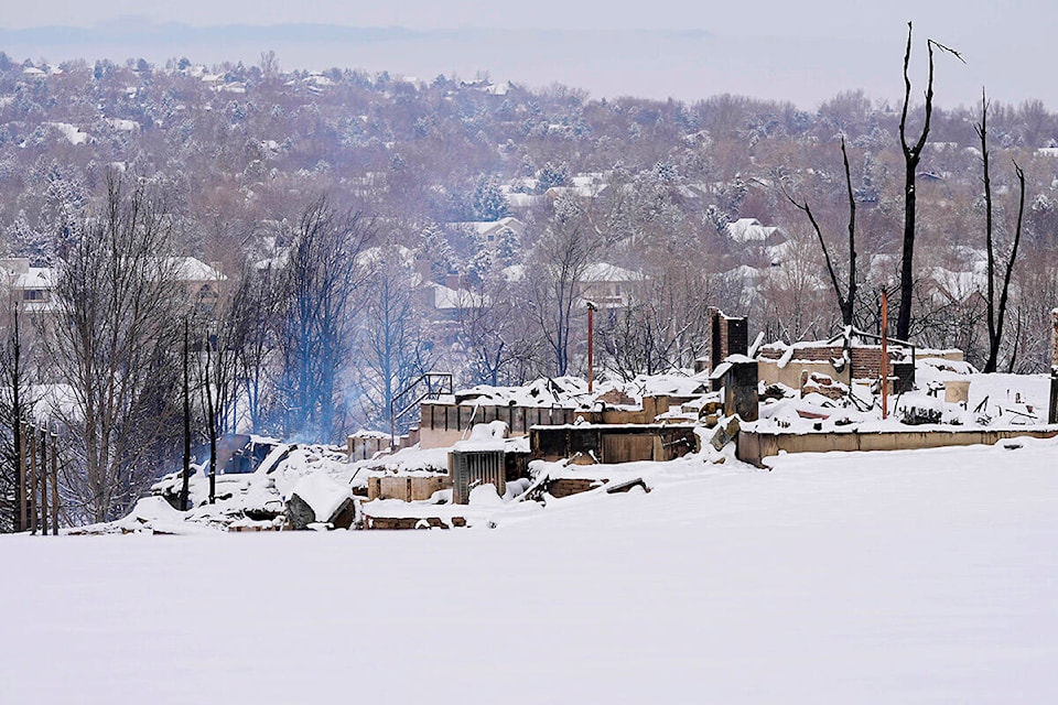 Snow covers the burned remains of homes in Louisville, Colo., on Saturday, Jan. 1, 2022, after the Marshall wildfire. (AP Photo/Jack Dempsey)