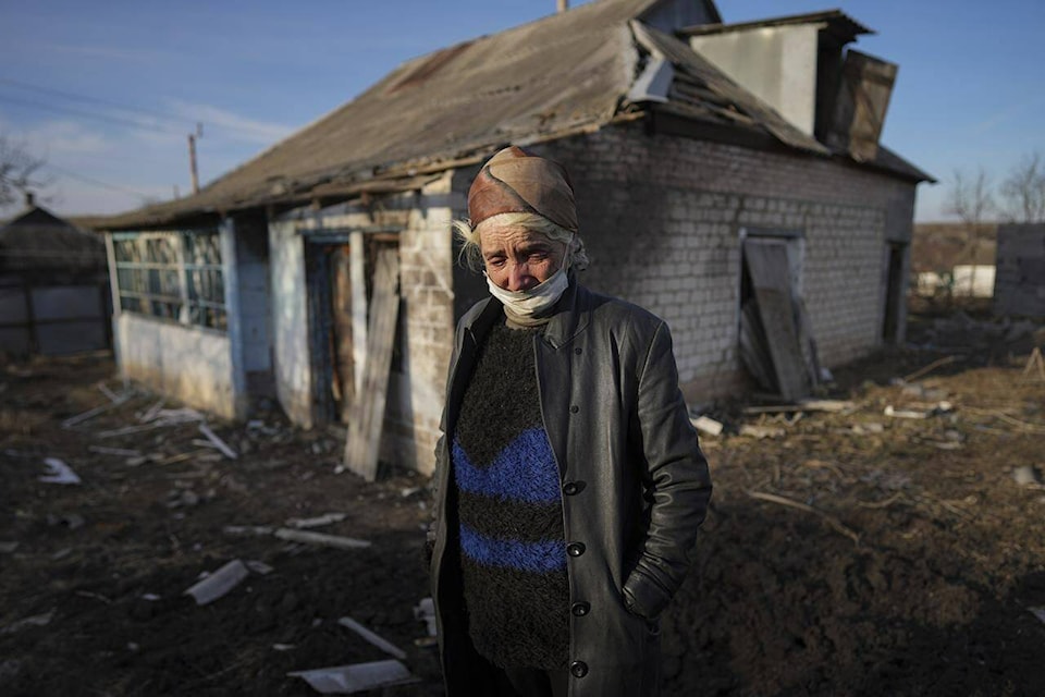 Tetyana Tomenko, a local resident, cries standing in front of her damaged house after alleged shelling by separatists forces in Novognativka, eastern Ukraine, Sunday, Feb. 20, 2022. Russia is extending military drills near Ukraine’s northern borders after two days of sustained shelling along the contact line between Ukrainian soldiers and Russia-backed separatists in eastern Ukraine. The exercises in Belarus, which borders Ukraine to the north, originally were set to end on Sunday. (AP Photo/Evgeniy Maloletka)