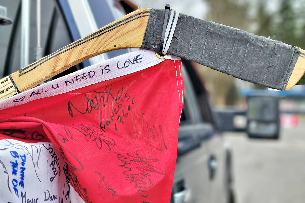 Ottawa convoy participant John Bancroft, organizer of a potluck barbecue and some parking lot hockey games for kids on Saturday, Feb. 26, at George Preston rec centre, brought a Canadian flag covered with signatures from the protest. (Dan Ferguson/Langley Advance Times)